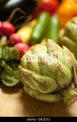 Close up portrait of organic artichaut et variété de légumes sur une planche à découper Banque D'Images