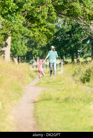 Petite fille et femme marche dans le vert paysage estival, Suède Banque D'Images