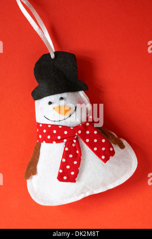 Le Snowman wearing foulard rouge à pois noir et top hat decoration prêt pour Noël sur fond rouge Banque D'Images