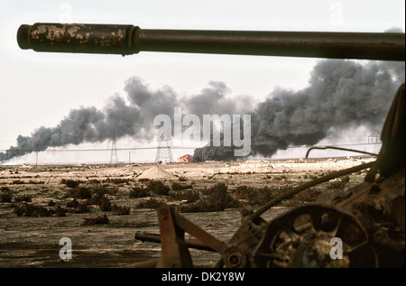 Un champ de pétrole koweïtiens incendiées par les troupes iraquiennes Burns dans la distance au-delà de l'Iraq à la suite de réservoir abandonné l'opération Tempête du désert, le 2 mars 1991 dans les champs de pétrole, le Koweït Ahman. Banque D'Images