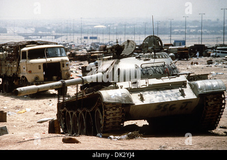 Un Irakien détruit T-55 char de combat principal, peint avec graffiti par les troupes de la Coalition, est situé au milieu d'autres véhicules détruits le long de la Route 8 Le Koweït, la route fuyant les forces iraquiennes ont pris comme ils se sont retirés du Koweït pendant l'opération Tempête du désert, le 18 avril 1991 au Koweït. La route est connue sous le nom de "l'autoroute de la mort" en raison du nombre de véhicules détruits par les forces alliées. Banque D'Images