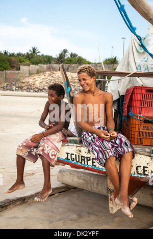 Les jeunes garçons assis sur un bateau de pêche, Jangada Fortaleza Iguape, district, le Brésil. Banque D'Images