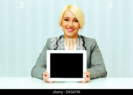 Young woman smiling businesswoman showing display d'un tablet computer in office Banque D'Images