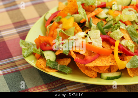 Tas de nachos avec légumes sur plaque verte. Banque D'Images