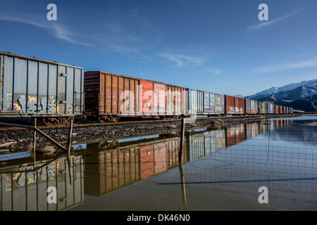 Wagons de chemin de fer en Utah, USA à côté d'un lac de sel inondée Banque D'Images