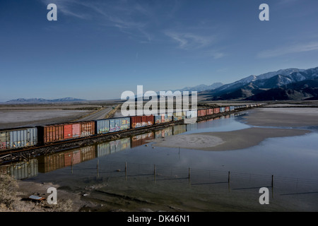 Wagons de chemin de fer en Utah, USA à côté d'un lac de sel inondée Banque D'Images