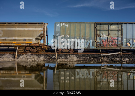 Wagons de chemin de fer en Utah, USA à côté d'un lac de sel inondée Banque D'Images