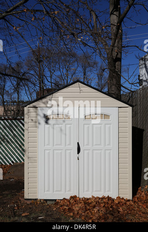 L'hangar de stockage à l'arrière-cour avec des feuilles sur le terrain Banque D'Images