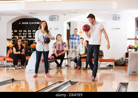 Man and Woman Holding Bowling Balls in Club Banque D'Images