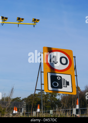 A 40 milles à l'heure limite de vitesse et la vitesse des signes d'avertissement de l'appareil photo avec des caméras sur le côté d'une autoroute Banque D'Images