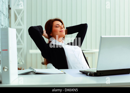 Young happy businesswoman resting in office Banque D'Images