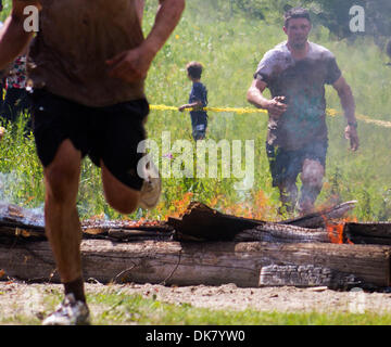 Jul 3, 2011 - Chelsea, Québec, Canada - un concurrent s'apprête à sauter par dessus le feu obstacle également connu sous le feu, l'Hades pour la finale challange Spartan Race à Camp Fortune, au Québec. 2500 concurrents sont attendus à la plus grande manifestation extrême de l'Est du Canada impliquant un 5km de course à obstacles, y compris les sauts de feu, de boue et des clôtures des fosses de belles forêts. (Crédit Banque D'Images