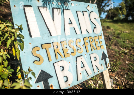 Un panneau pour Ivan's Bar à White Bay sur Jost Van Dyke dans les îles Vierges britanniques. Connue pour sa vie marine diversifiée et ses récifs coralliens, la région des Caraïbes compte parmi les plages les plus belles et les mieux préservées du monde. Banque D'Images