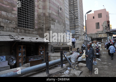 Une rue de terre décrépite le long d'une immense mosquée dans le quartier islamique de la capitale égyptienne le Caire. Banque D'Images