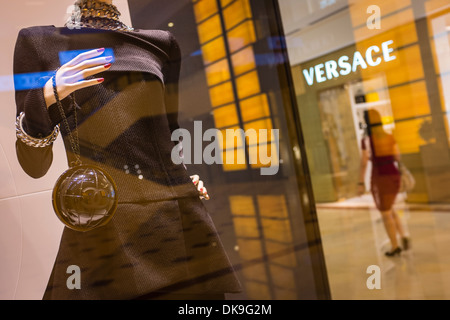 Une femme marche par le Chanel et Versace, boutiques dans le centre commercial Suria KLCC à Kuala Lumpur Banque D'Images