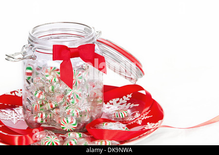 Noël Pinwheel de bonbons dans un bocal de verre, affichée sur la plaque de maison rouge Banque D'Images