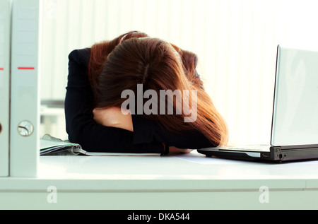 Jeune femme d'fatigué dormir à son lieu de travail dans office Banque D'Images