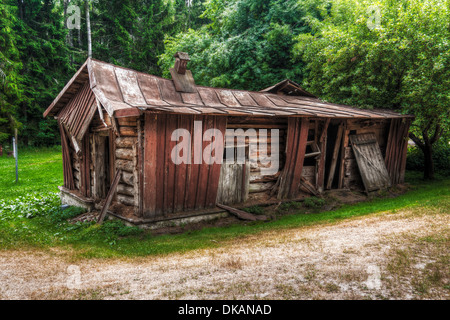 Ancienne maison en bois avec du bois s'est effondré en vert forêt. Banque D'Images