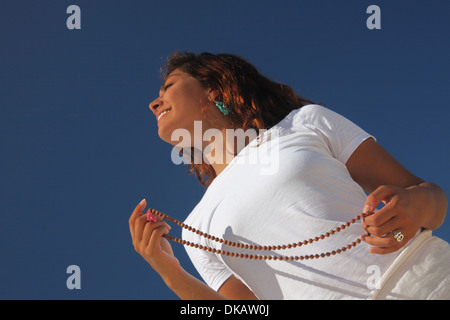 Young woman holding beads on beach, Paradise Island, Nassau, Bahamas Banque D'Images