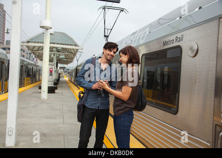 Couple listening to earphones partagée à la station, Los Angeles, Californie, USA Banque D'Images