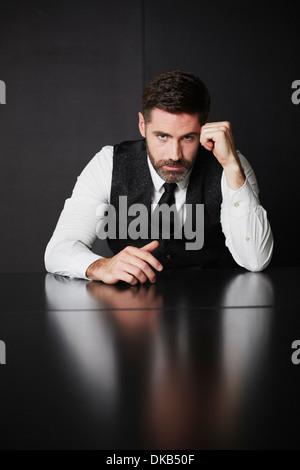 Businessman wearing shirt gilet et s'appuyant sur le coude Banque D'Images