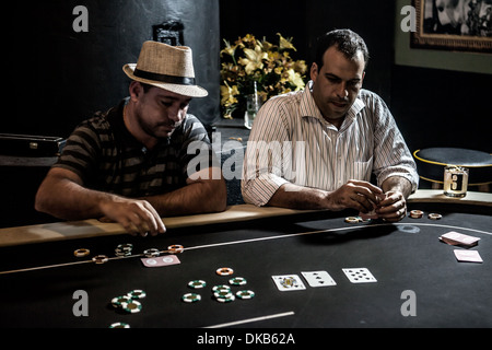 Mi les hommes adultes jouer au poker et boire des cocktails Banque D'Images