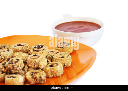 Biscottes avec graines de sésame, les olives sur plaque orange et sauce rouge isolé sur fond blanc. Banque D'Images