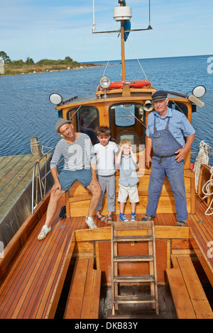 Son père et ses deux fils avec pêcheur sur un bateau, Eggergrund, Suède Banque D'Images