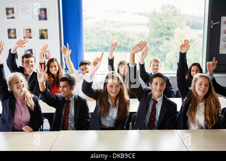 Les écoliers avec les mains posées en classe Banque D'Images