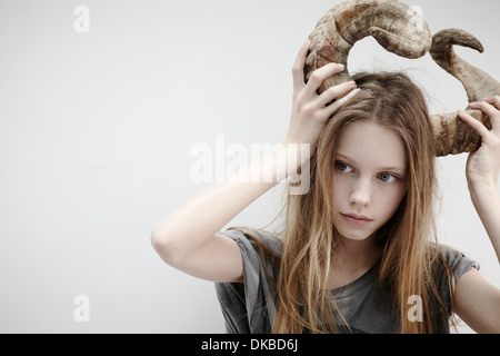 Portrait of Girl holding cornes sur sa tête Banque D'Images