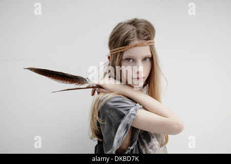 Portrait of Girl wearing tresse cuir autour de tête, holding feather Banque D'Images