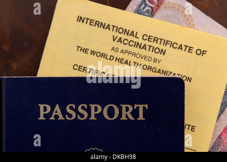 Un ensemble de documents de voyage dont Passeport Certificat international de vaccination et de service situé sur un fond brun Banque D'Images
