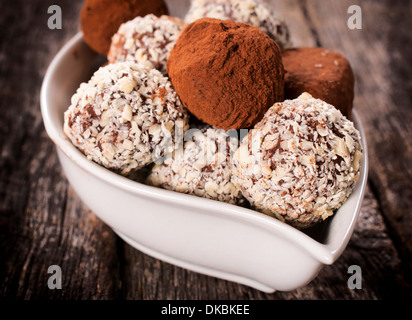 Pralines faites maison dans le bol blanc sur la table en bois Banque D'Images