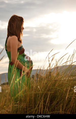 Pregnant woman standing in field Banque D'Images