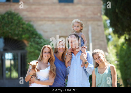 Les parents debout avec ses filles et le chien dans le jardin Banque D'Images