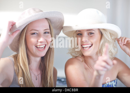 Les jeunes femmes d'essayer sur des chapeaux Banque D'Images