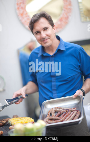 Man barbecuing sausages Banque D'Images