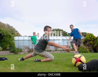 Père et fils à jouer au football dans le jardin Banque D'Images