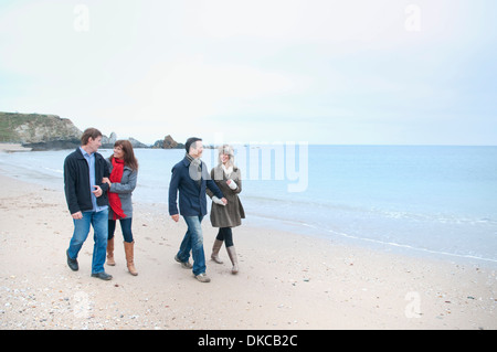Deux couples adultes walking on beach, Thurlestone, Devon, UK Banque D'Images
