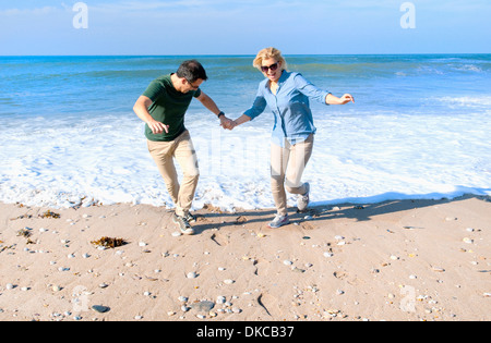 Couple de jouer sur la plage, Thurlestone, Devon, UK Banque D'Images