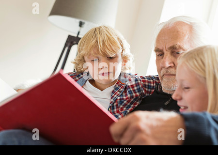 Livre de lecture grand-père à ses petits-enfants Banque D'Images