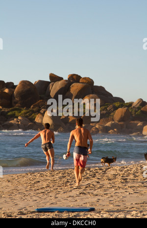 Deux jeunes hommes jouent au football sur la plage de Llandudno, Cape Town Banque D'Images