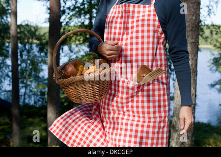 Femme avec panier de champignons en forêt Banque D'Images