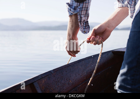 L'homme sur le bateau avec une corde, Aure, Norvège Banque D'Images