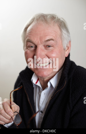 Close up portrait of senior man holding spectacles Banque D'Images