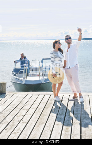 Couple photographing themselves on pier, Gavle, Suède Banque D'Images