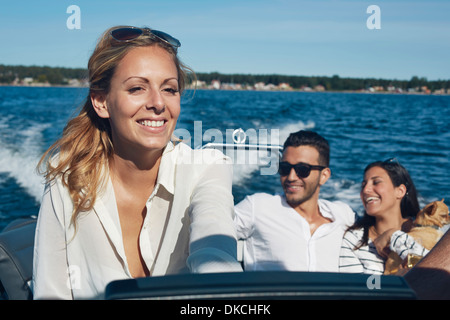 Jeune femme bateau de direction avec des amis en arrière-plan, Gavle, Suède Banque D'Images