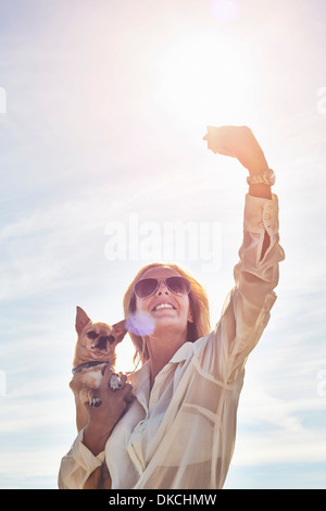 Jeune femme elle-même photographier avec chien Banque D'Images