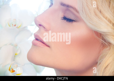 Close up of woman smelling orchidées Banque D'Images