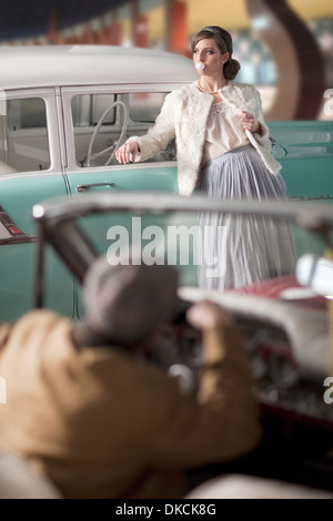 Man woman leaning on vintage car Banque D'Images